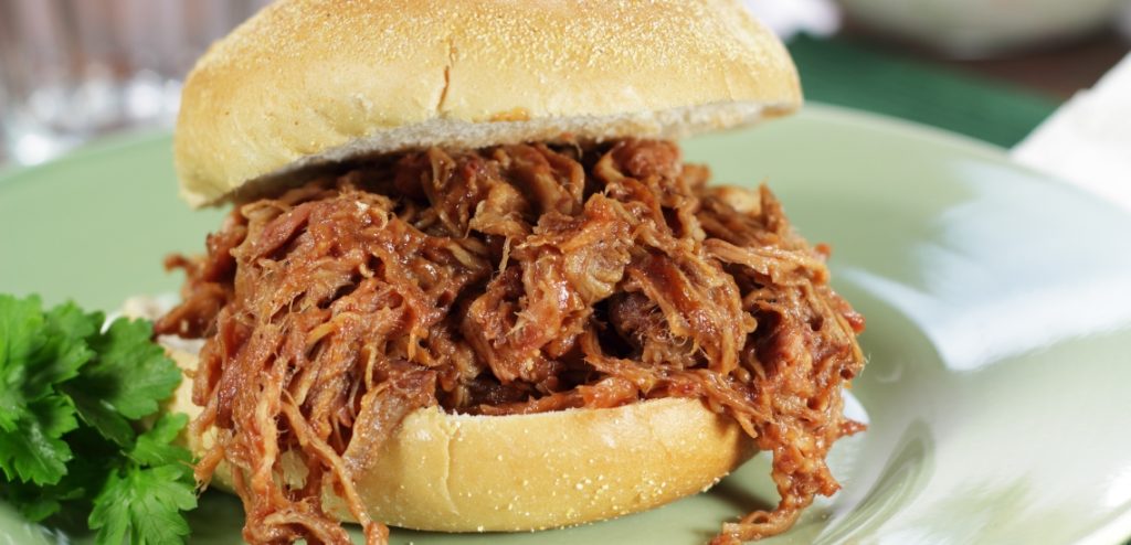 A Sandwich Made With Pulled Pork That Has Been Marinated In Hot Sauce For An Extended Period Of Time